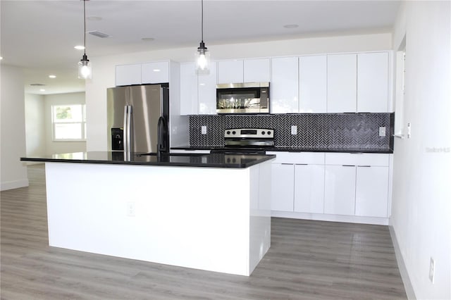 9085 Dorsey St, Spring Hill, FL 34608 - kitchen with stainless steel appliances, modern cabinets, white cabinets, backsplash, and dark countertops