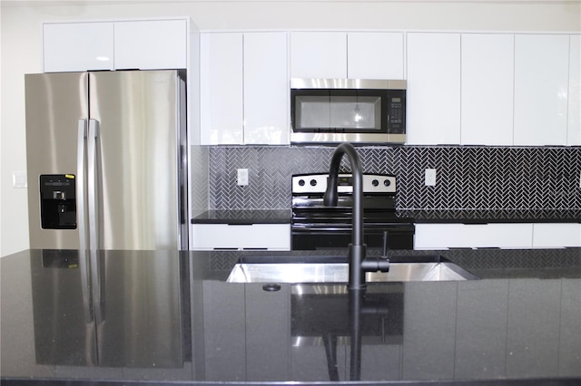 9085 Dorsey St, Spring Hill, FL 34608 - kitchen featuring stainless steel appliances, white cabinets, modern cabinets, dark countertops, and tasteful backsplash