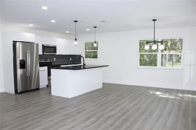 9085 Dorsey St, Spring Hill, FL 34608 - kitchen with appliances with stainless steel finishes, dark countertops, recessed lighting, white cabinets, and light wood-style floors