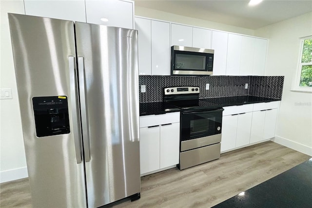 kitchen with decorative backsplash, light hardwood / wood-style floors, white cabinetry, and stainless steel appliances