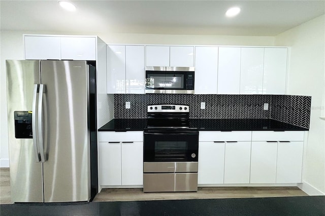 kitchen with white cabinetry, dark wood-type flooring, stainless steel appliances, and tasteful backsplash