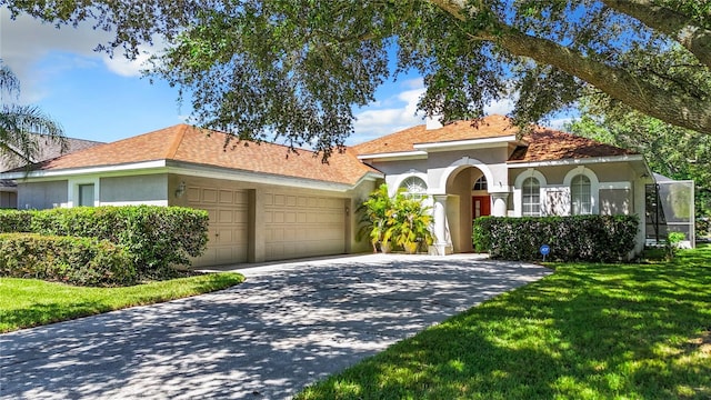 mediterranean / spanish-style home featuring a garage and a front lawn