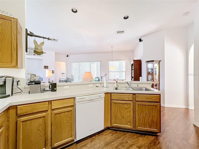 kitchen featuring wood-type flooring, sink, kitchen peninsula, hanging light fixtures, and white dishwasher