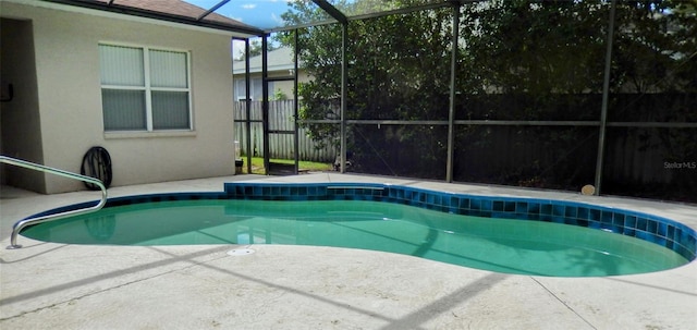 view of pool with glass enclosure and a patio area