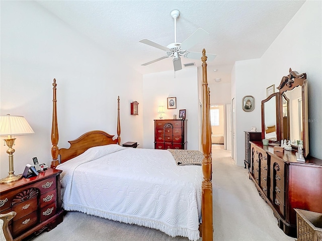 bedroom with a textured ceiling, light carpet, and ceiling fan