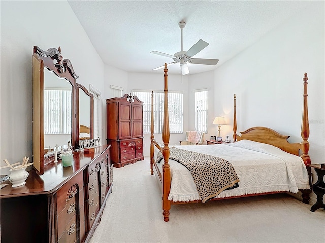 bedroom featuring ceiling fan, a textured ceiling, and light carpet