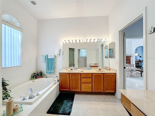 bathroom with tiled bath and vanity