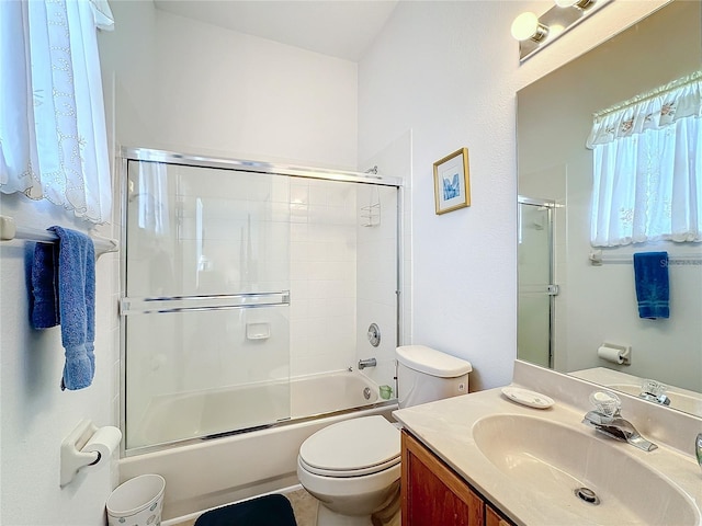 full bathroom with combined bath / shower with glass door, vanity, toilet, and tile patterned flooring