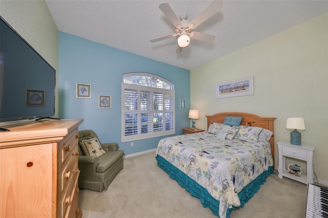 carpeted bedroom with ceiling fan and a textured ceiling