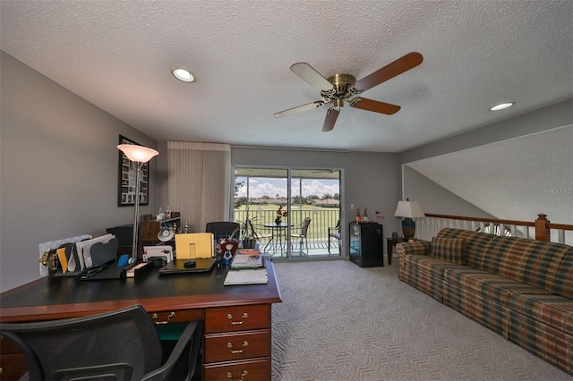 carpeted office featuring ceiling fan and a textured ceiling