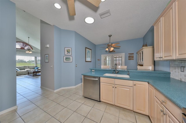 kitchen featuring dishwasher, a textured ceiling, sink, light brown cabinets, and light tile patterned floors