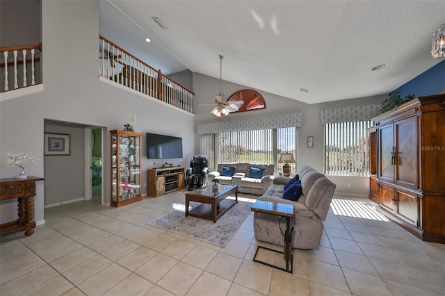 tiled living room featuring ceiling fan, a textured ceiling, and high vaulted ceiling