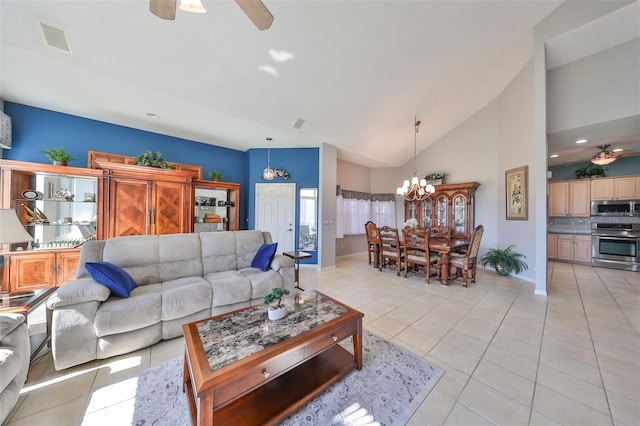 living room with light tile patterned flooring, ceiling fan with notable chandelier, and high vaulted ceiling