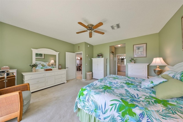 carpeted bedroom with a textured ceiling, connected bathroom, and ceiling fan