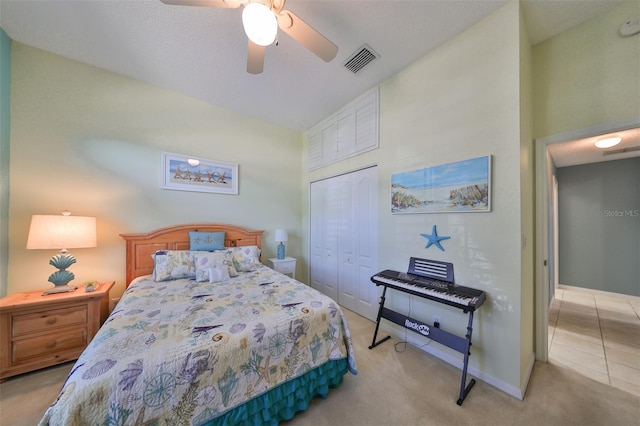 carpeted bedroom with ceiling fan and a closet