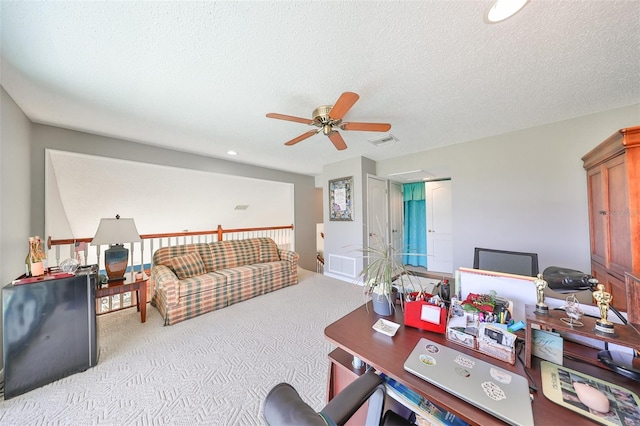 carpeted office with ceiling fan and a textured ceiling