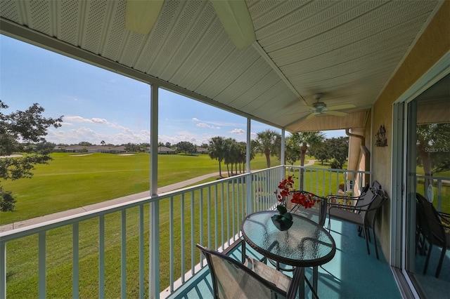 unfurnished sunroom featuring ceiling fan