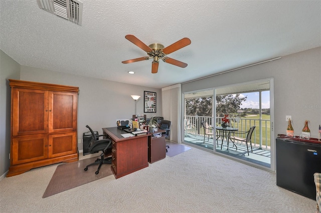 office area featuring ceiling fan, light colored carpet, and a textured ceiling