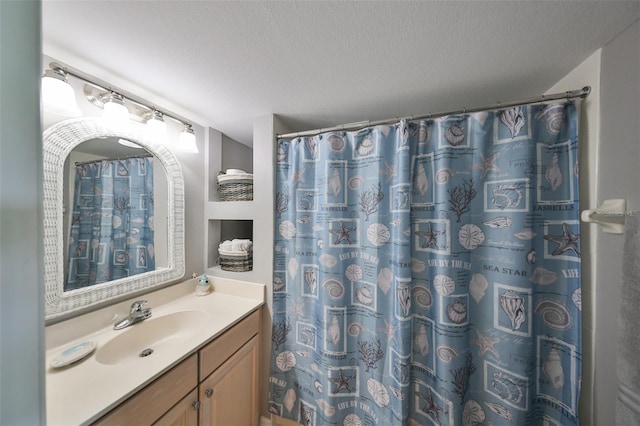 bathroom featuring vanity, a textured ceiling, and curtained shower