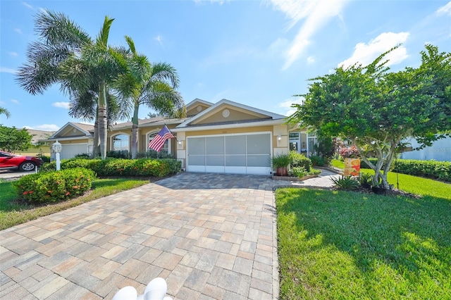 single story home with a front yard, decorative driveway, an attached garage, and stucco siding