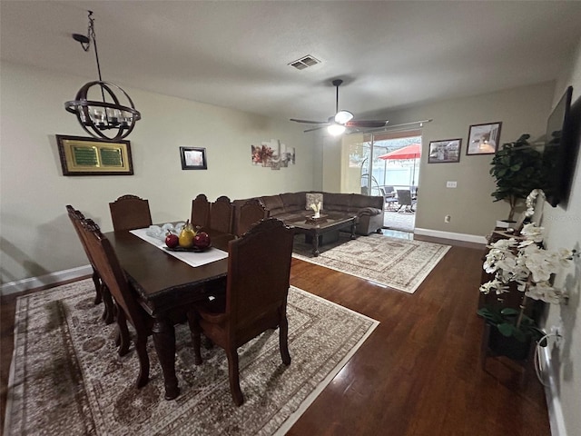 dining room featuring ceiling fan with notable chandelier and dark wood-type flooring