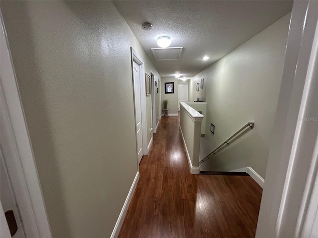 hallway featuring a textured ceiling and dark hardwood / wood-style flooring