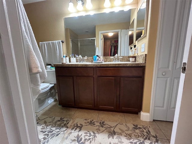 bathroom with tile patterned flooring, vanity, toilet, and a shower with shower door