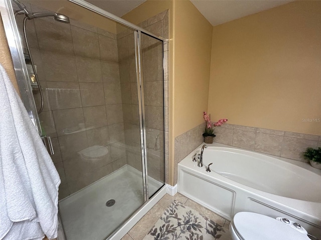 bathroom featuring plus walk in shower, tile patterned floors, and toilet