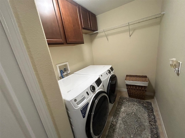 laundry area with washer and dryer and cabinets