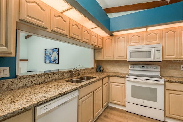 kitchen featuring light brown cabinetry, sink, light wood-type flooring, light stone countertops, and white appliances