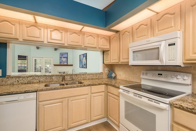 kitchen featuring sink, light brown cabinets, and white appliances