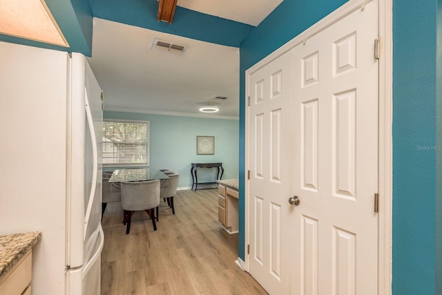 hallway with crown molding and light wood-type flooring