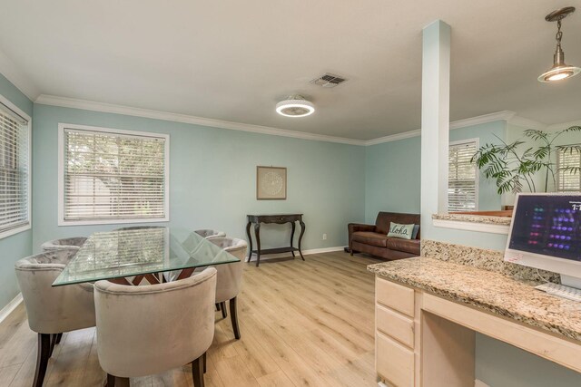 dining room with ornamental molding, light hardwood / wood-style flooring, and a wealth of natural light