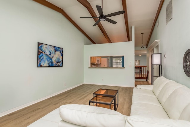 living room featuring hardwood / wood-style flooring, ceiling fan, high vaulted ceiling, and beam ceiling