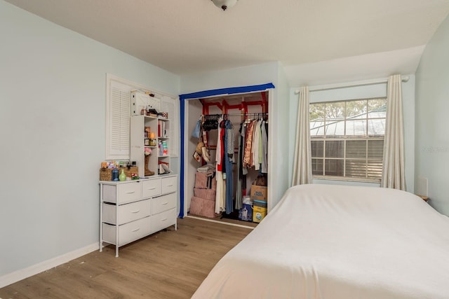 bedroom with light hardwood / wood-style floors and a closet