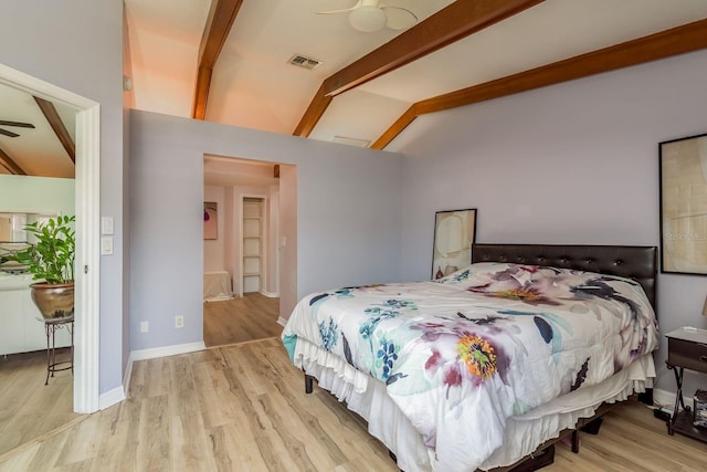 bedroom with ceiling fan, light wood-type flooring, and vaulted ceiling with beams