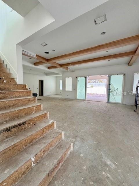 unfurnished living room featuring beamed ceiling