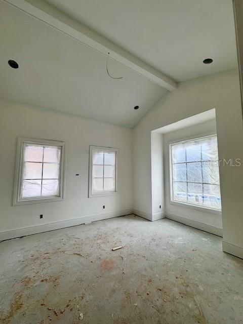 spare room featuring plenty of natural light and lofted ceiling with beams