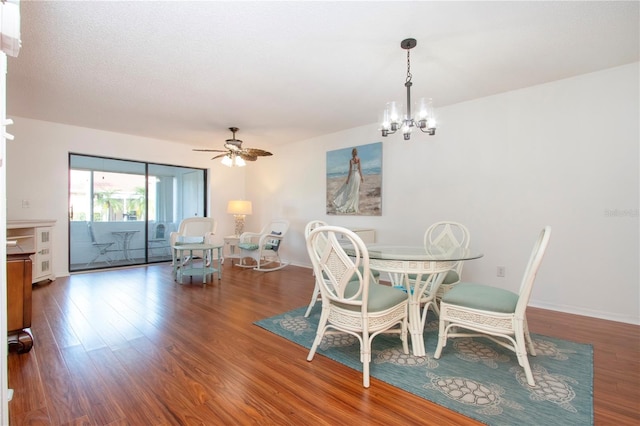 dining area featuring wood-type flooring and ceiling fan with notable chandelier