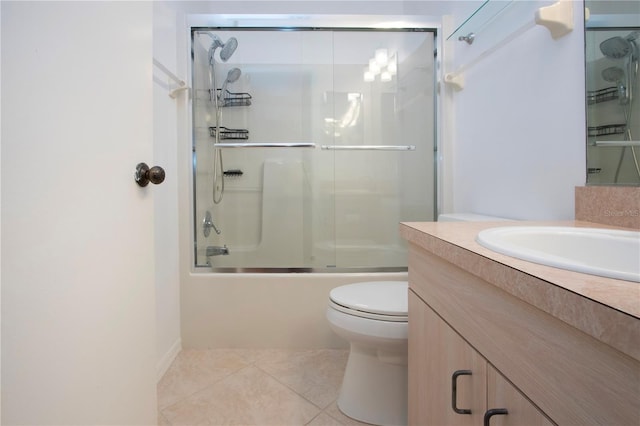 full bathroom featuring shower / bath combination with glass door, vanity, tile patterned flooring, and toilet