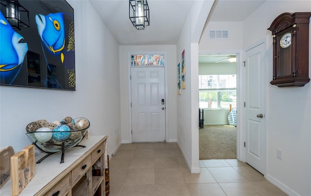 entryway with light tile patterned floors, baseboards, and visible vents