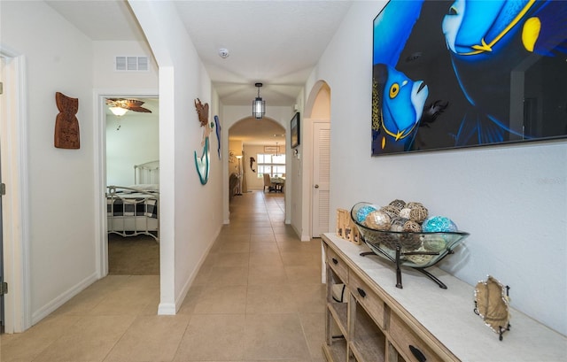1523 Glen Grove Loop, Wesley Chapel, FL 33543 - hallway featuring arched walkways, light tile patterned floors, and baseboards