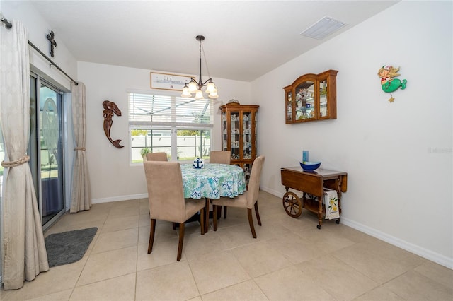 dining area with light tile patterned floors and an inviting chandelier