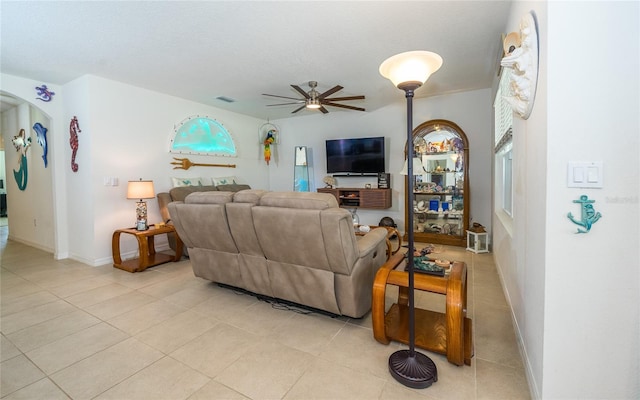 living room featuring light tile patterned floors, ceiling fan, visible vents, and baseboards