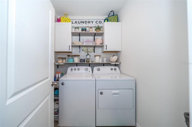 laundry room with independent washer and dryer and cabinet space