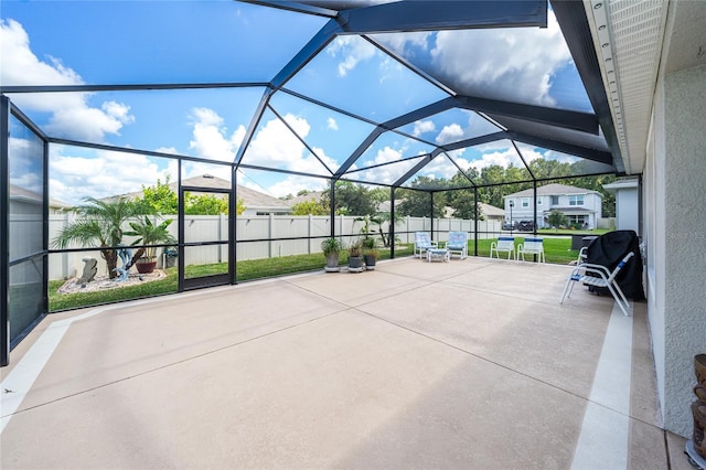 view of patio with glass enclosure and a fenced backyard