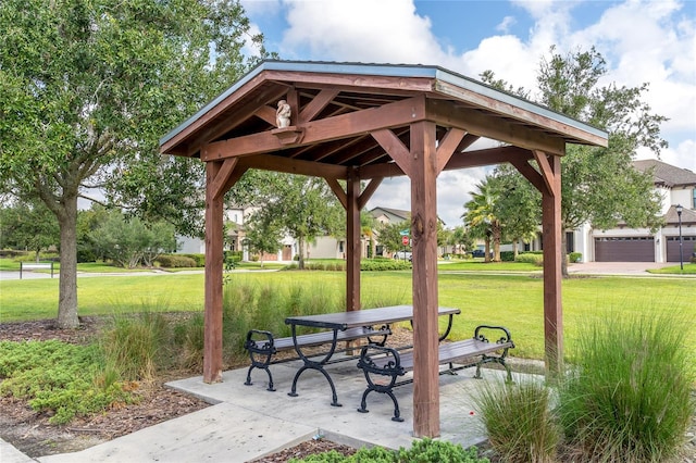 view of property's community with a garage, a gazebo, and a lawn