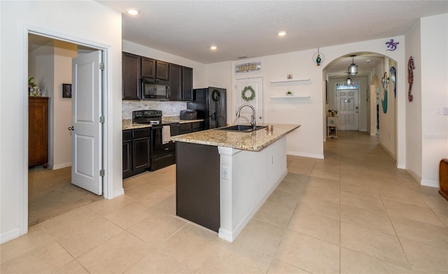 1523 Glen Grove Loop, Wesley Chapel, FL 33543 - kitchen featuring black appliances, a sink, arched walkways, light tile patterned floors, and decorative backsplash
