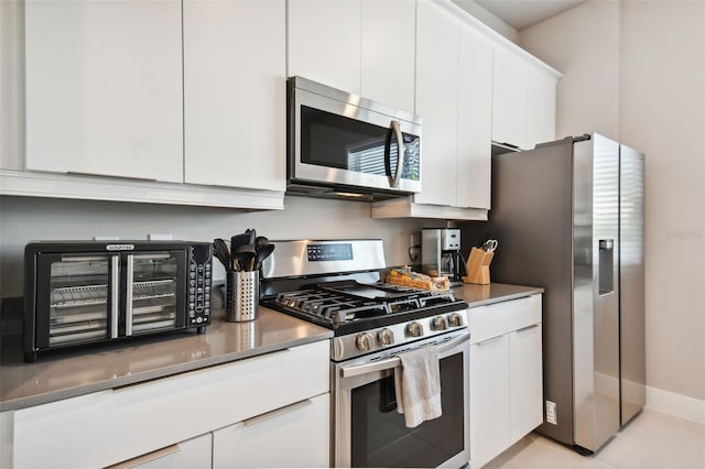 kitchen featuring white cabinetry, appliances with stainless steel finishes, and light tile patterned flooring