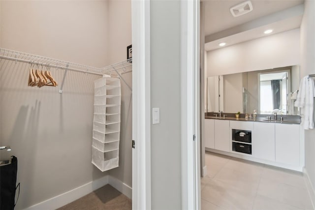 walk in closet featuring light tile patterned floors and sink